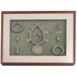A collection of Oman silver and silver coloured jewellery, eight pieces mounted and framed,