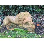 A terracotta recumbent lion, stamped Phillips Weston Super Mare,