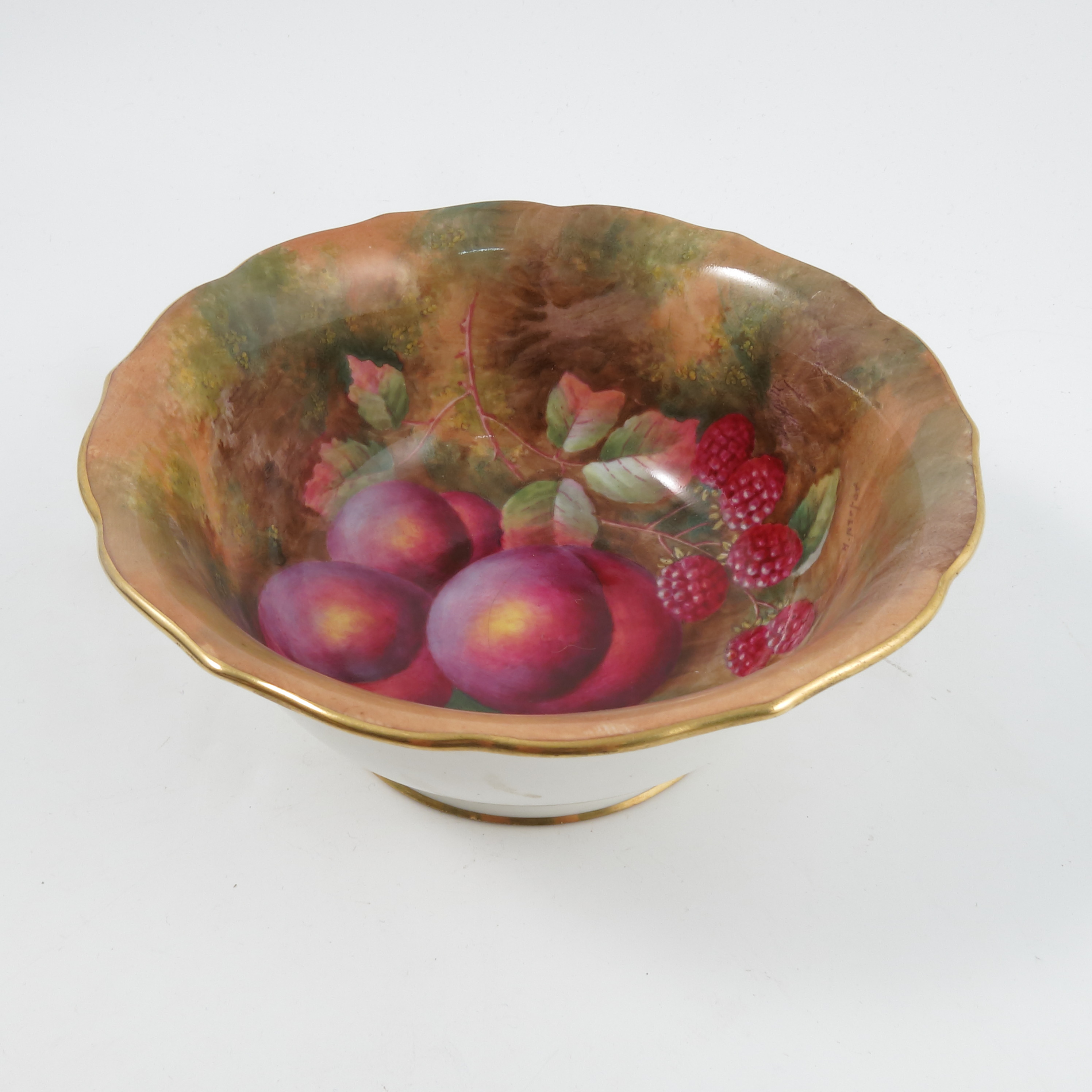 A Royal Worcester bowl, the interior painted with fruit to a mossy background by H Aryton,