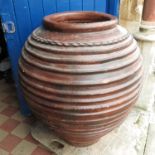 A large pottery olive jar, with ribbed decoration,