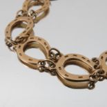 A 9 carat gold bracelet, composed of twelve horseshoe links, 21cm long, 9.