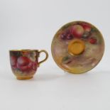 A Royal Worcester cabinet cup and saucer, decorated with fruit to a mossy background,