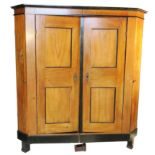 A Biedermeier style wardrobe, having two panelled doors, with ebonised banding and canted corners,