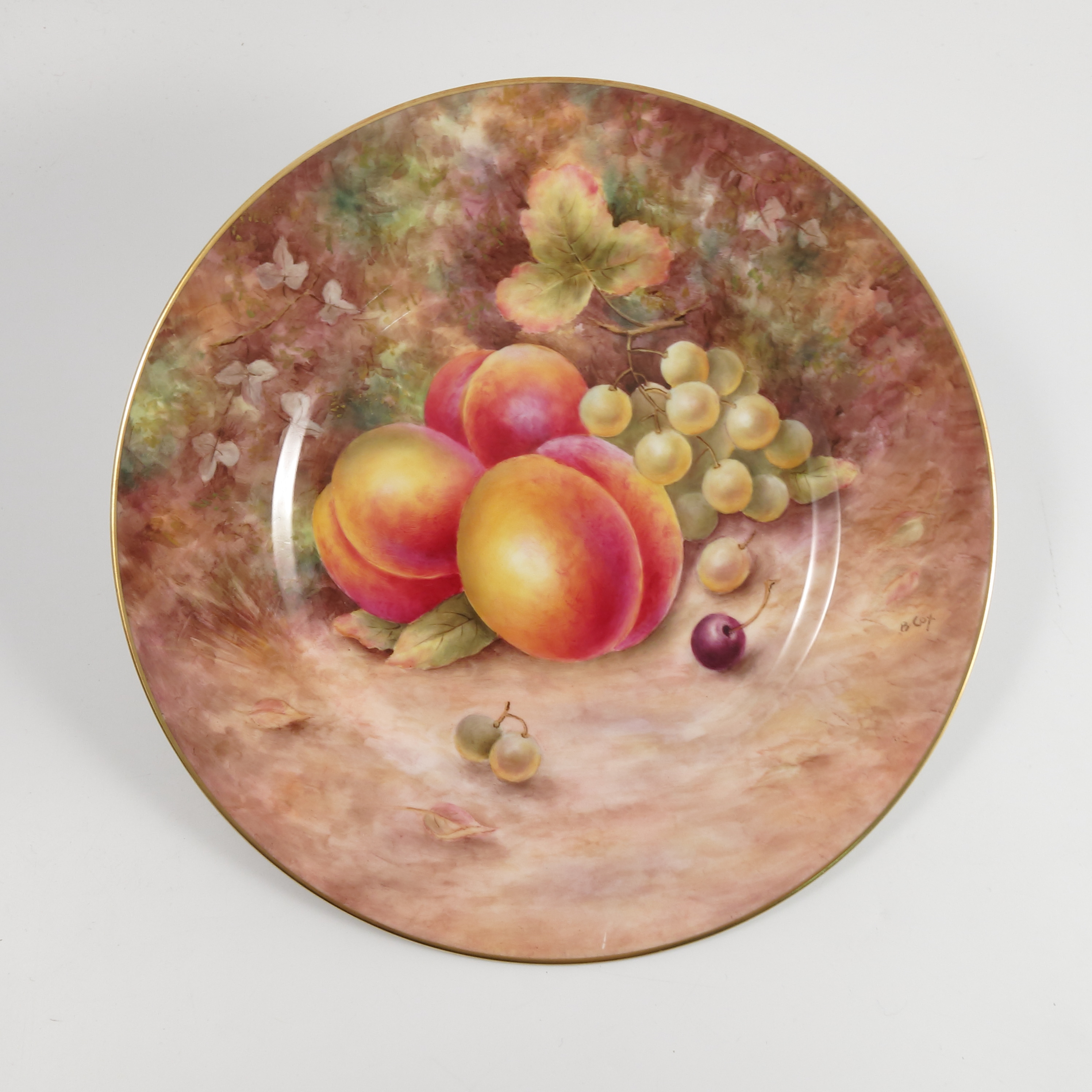 A Royal Worcester plate, decorated with fruit to a mossy background by B Cox, diameter 10.