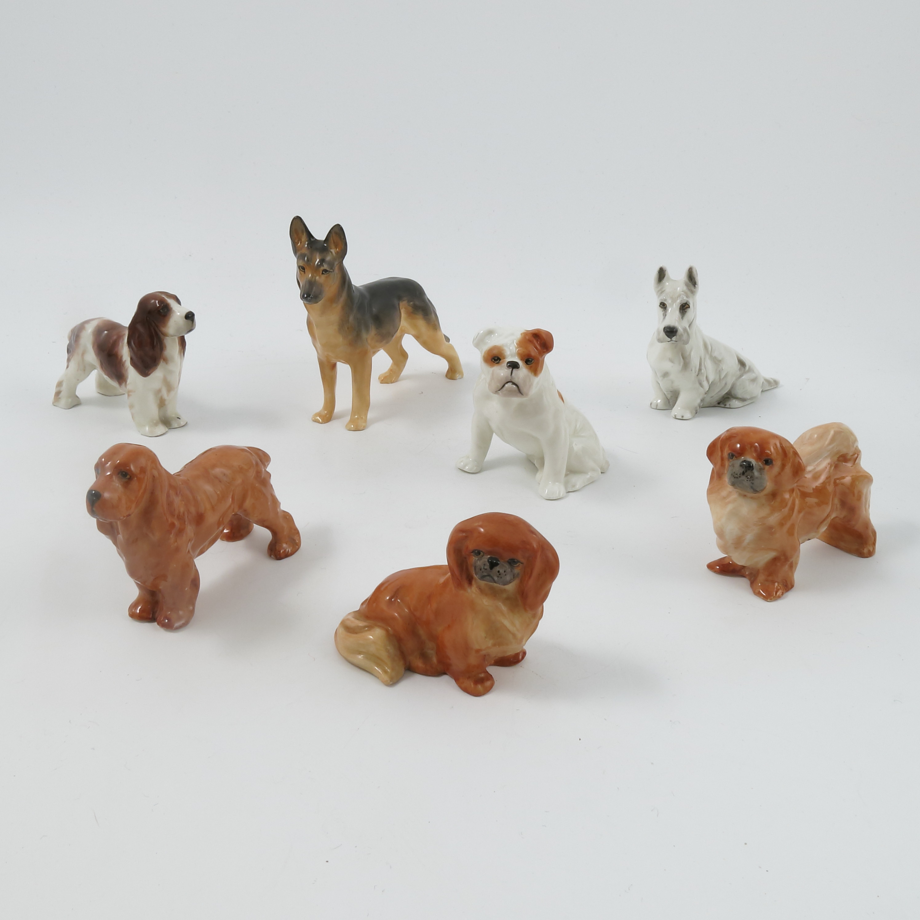Seven Royal Worcester small dog models, by Doris Lindner, comprising Pekingese Sitting, shape no.