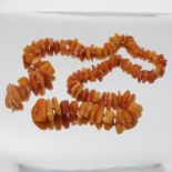 A row of tumbled 'butterscotch' amber beads, with another row of smaller tumbled amber beads,