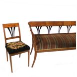 A Biedermeier style suite, comprising a sofa with ebonised splat back and out swept feet,
