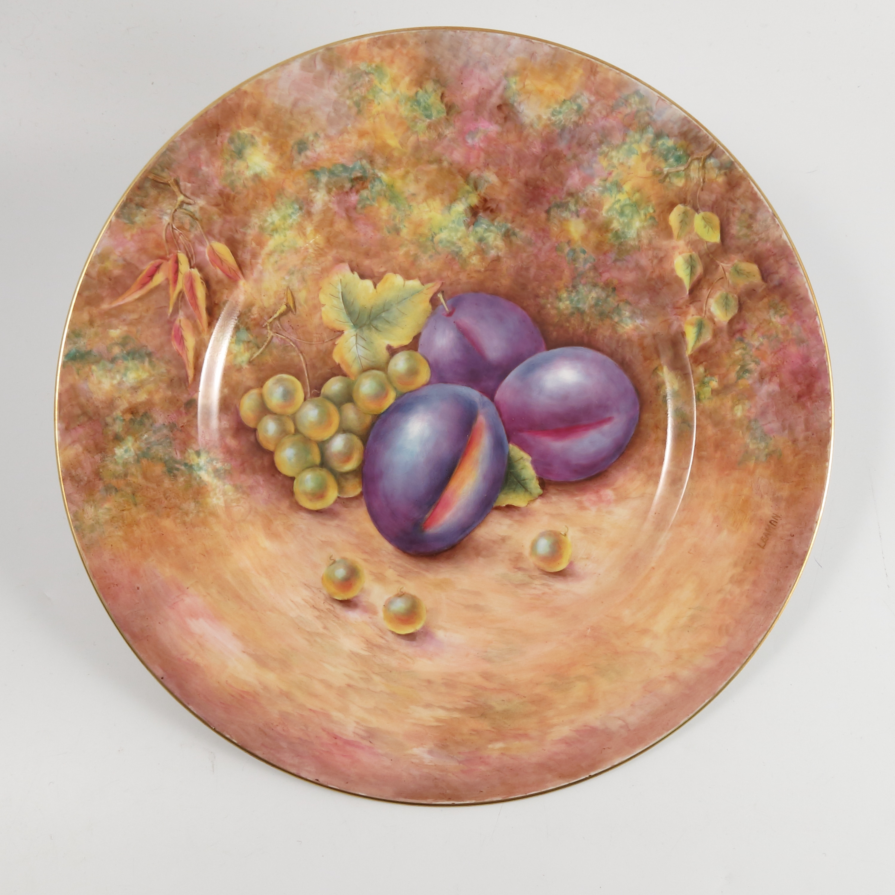 A Royal Worcester plate, decorated with fruit to a mossy background by Leaman, diameter 10.