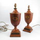 A pair of wooden lamp bases, of urn form, decorated with roundels and swags,