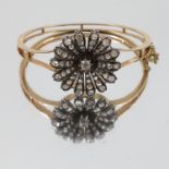 A late Victorian diamond flower head cluster to a hinged bangle, circa 1890,