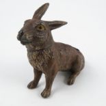 A cold painted bronze inkwell and pen wipe, modelled as a seated rabbit, with hinged head,