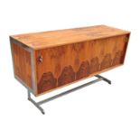 A 1970s rosewood sideboard, having two cupboards each side with a glass shelf, and chrome supports,