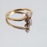 A two stone diamond crossover ring, stamped '18ct',