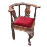 An oak corner chair, with turned eagle arms and carved dolphin splats,