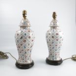 A pair of porcelain lamp bases, of baluster form with covers,