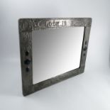 An Arts and Crafts pewter mounted wall mirror,