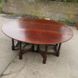A reproduction oak gateleg dining table, raised on turned supports,
