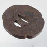 A Japanese tsuba, decorated with foliage, stylised and gilt piques