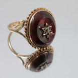 A garnet ring, stamped '9ct', star set to the cent