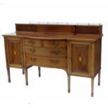 An Edwardian bow front sideboard, having a galleried top over a central panel flanked by doors, over
