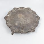 A silver salver, with embossed shaped edge, bearing coat of arms and inscription to centre, raised