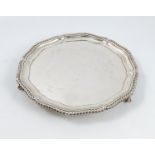 A silver salver, with gadrooned edge, raised on three ball and claw feet, Sheffield 1907, weight