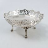 A silver dish, of shaped circular form with pierced edge, raised no four reeded legs and paw feet,
