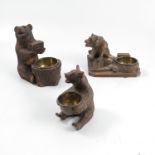 Three Black Forest carved bear vestas, on naturalistic bases