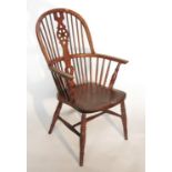 A 19th century wheel back Windsor arm chair, raise