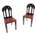 A pair of mahogany hall chairs, of Gothic design,