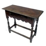 An antique oak side table, with carved single drawers over frieze, raised on four turned legs united
