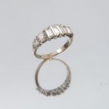 A seven stone diamond 14 carat white gold ring, set with three baguettes to the centre, flanked by a