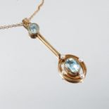 An Edwardian aquamarine and seed pearl pendant, stamped '9ct', the oval cut stone suspended within