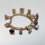 A 9 carat gold bracelet, of solid curb links, with seal fobs and two charms attached, some are