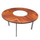A 1970s rosewood circular table, with white melamine lazy Susan centrepiece, raised on four chrome
