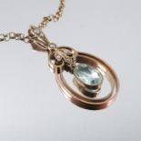 An Edwardian aquamarine and seed pearl pendant, stamped '15ct', the oval cut stone with a pearl to