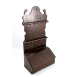 A 19th century spoon rack, with shield shaped back and having a sloping candle box below, width 12.
