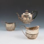 A silver bachelor's three piece tea set, of oval form with gadrooned lower body, Sheffield 1899,