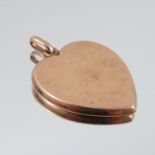 A large plain heart locket pendant, stamped '9' to the bale, opening to reveal a picture