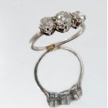 A three stone diamond ring, unmarked, the graduated old brilliant cut stones totalling approximately