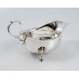 A silver sauce boat, with shaped edge, scroll handle and raised on three scroll feet, Chester