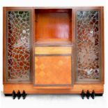 An Art Deco cabinet, fitted with two geometric lead glazed doors, flanking a central breakfront