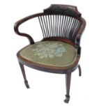 An Edwardian tub chair, with carved decoration over spindle back, raised on front tapering legs