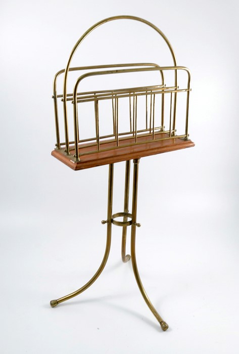 An Edwardian brass two division revolving magazine rack, on a mahogany base, to a brass three-legged