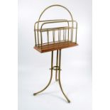 An Edwardian brass two division revolving magazine rack, on a mahogany base, to a brass three-legged