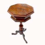 A 19th century octagonal walnut tea table, the rising lid opening to reveal tea canisters and