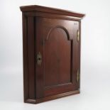 A small mahogany corner cupboard, with arched panel door, opening to reveal a shelf, height 17ins