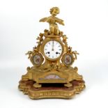 A gilt metal and porcelain mantle clock, with panels of putti and arrows and bow with flowers, the