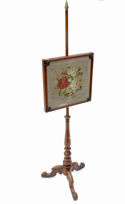 A 19th century walnut pole screen, the tapestry screen decorated with flowers, raised on a turned