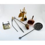 A group of brass implements, to include three skimmers, an andiron etc, together with a copper